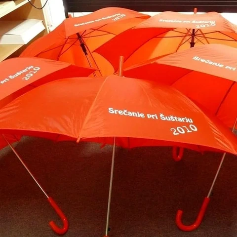 Oranžni dežniki z belim tiskom