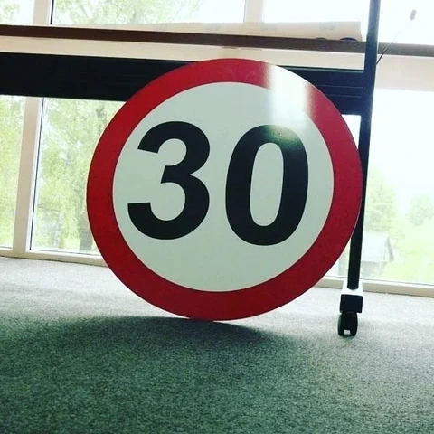 Okrogla tabla v obliki prometnega znaka s številko 30
